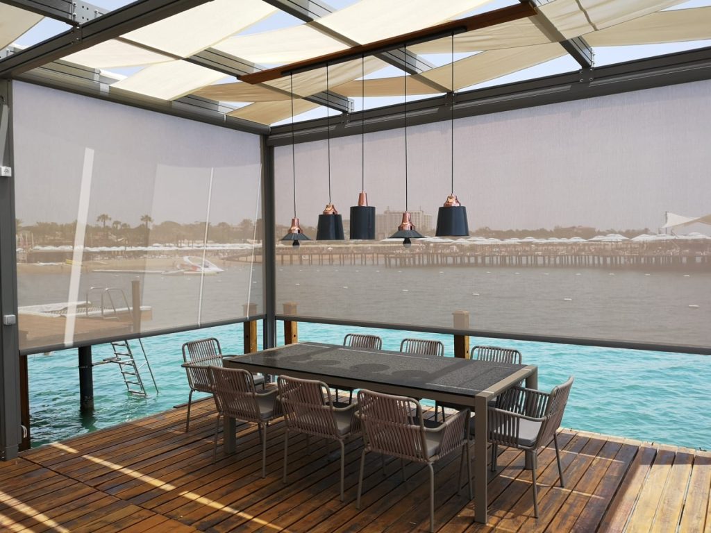 Zip perde sistemi ile kapatılmış modern kış bahçesi alanı